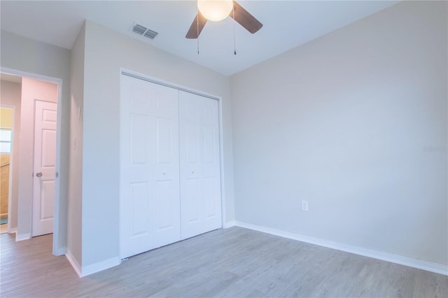 unfurnished bedroom featuring ceiling fan, light hardwood / wood-style flooring, and a closet