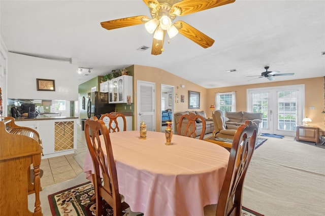 dining space featuring lofted ceiling, light tile patterned flooring, ceiling fan, and french doors