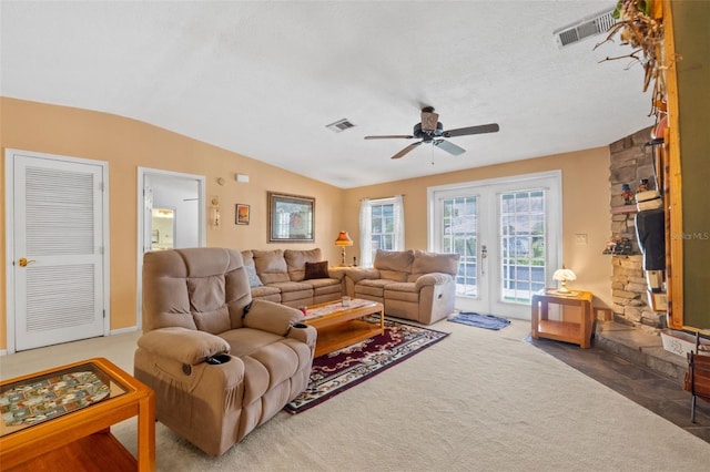 living room with carpet floors, a textured ceiling, vaulted ceiling, and ceiling fan