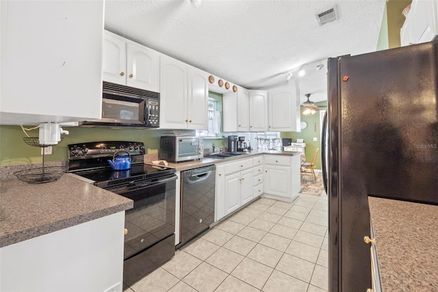 kitchen featuring a textured ceiling, black appliances, white cabinetry, and sink