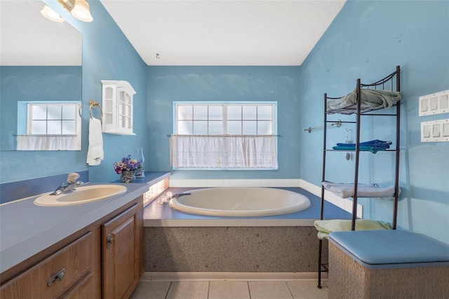 bathroom with tile patterned flooring, vanity, a tub, and a wealth of natural light