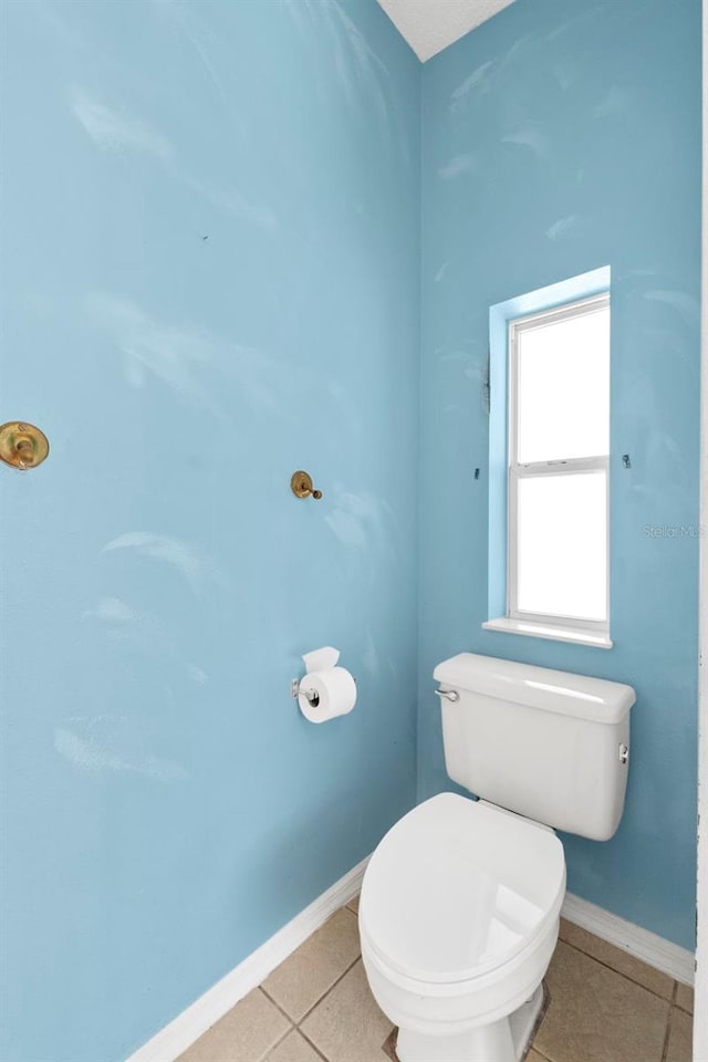 bathroom with toilet and tile patterned floors