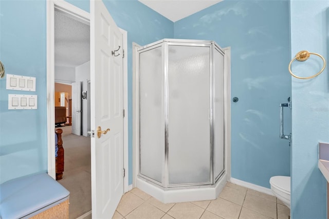 bathroom with a textured ceiling, tile patterned flooring, a shower with door, and toilet