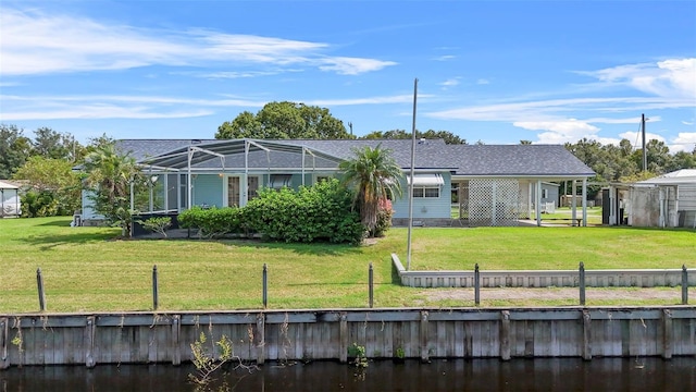 back of house featuring a yard and a lanai