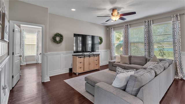 living room with ceiling fan, dark wood-type flooring, and a textured ceiling