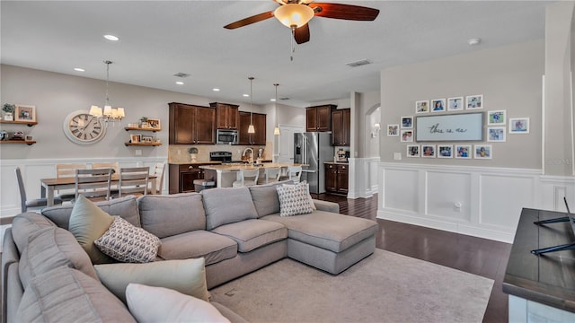 living room featuring ceiling fan with notable chandelier, dark hardwood / wood-style floors, and sink