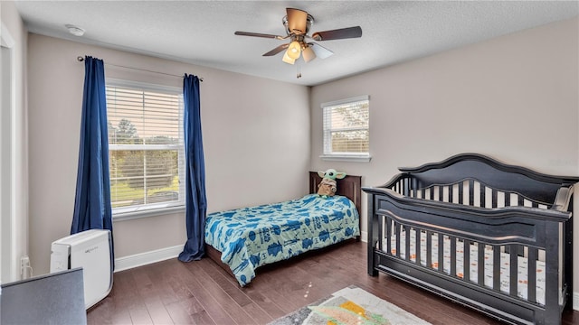 bedroom featuring ceiling fan, a textured ceiling, and dark hardwood / wood-style floors