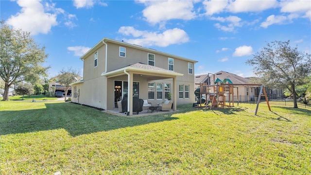 rear view of house featuring a playground, a yard, an outdoor living space, and a patio area