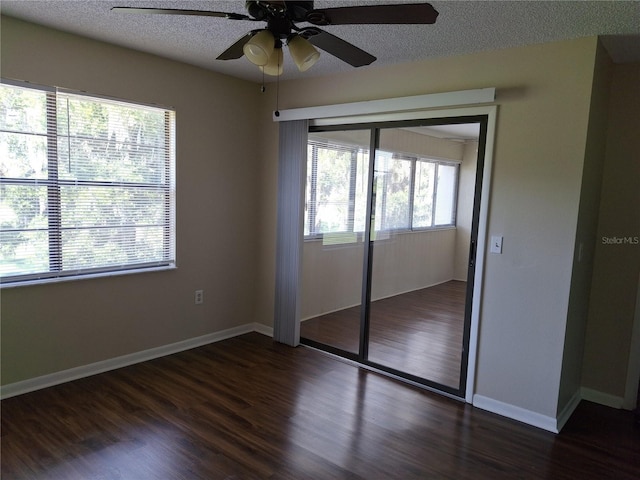 unfurnished bedroom featuring dark wood-type flooring, a closet, multiple windows, and ceiling fan