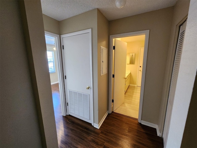 hall featuring a textured ceiling and dark wood-type flooring