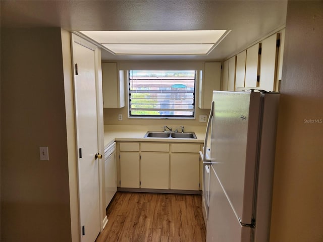 kitchen with light hardwood / wood-style floors, white fridge, and sink