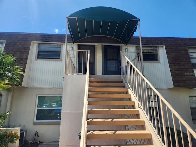 6128 Topher Trl Unit 6128, Mulberry, FL 33860 - entrance to property featuring stucco siding, central AC unit, and roof with shingles