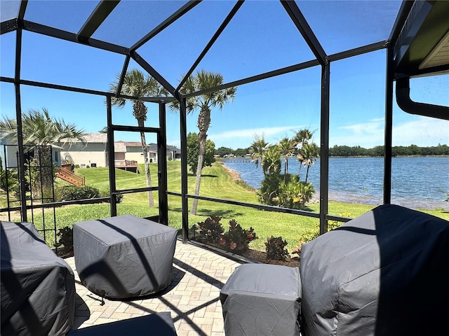 sunroom featuring lofted ceiling and a water view