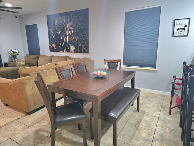 dining room featuring baseboards, ceiling fan, and light tile patterned floors