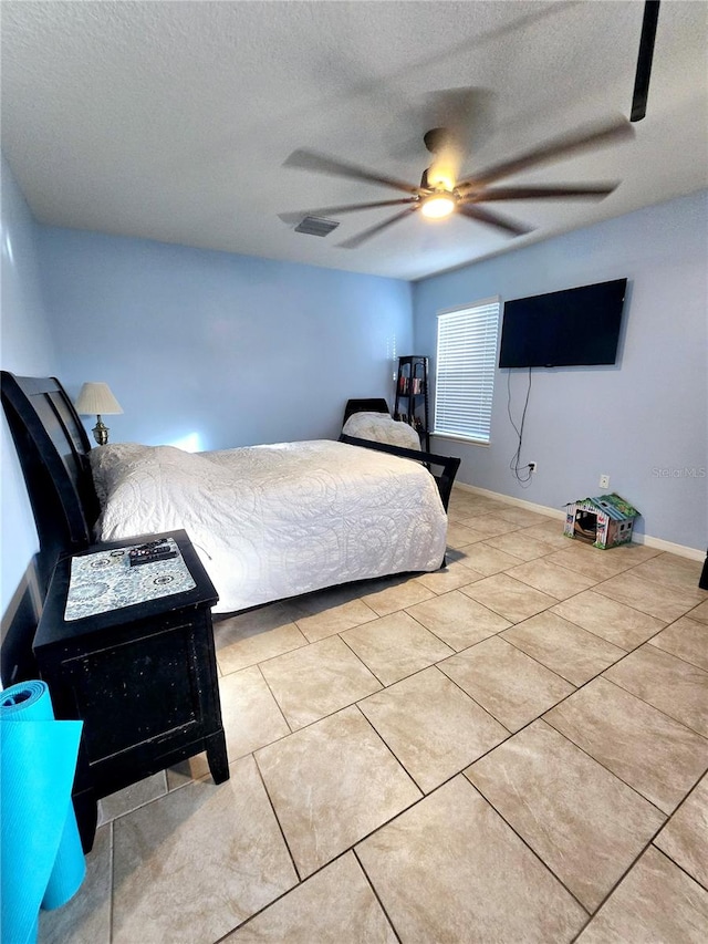 tiled bedroom with a textured ceiling and ceiling fan