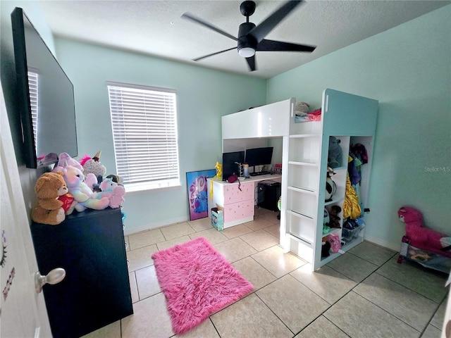 tiled bedroom featuring ceiling fan and a textured ceiling