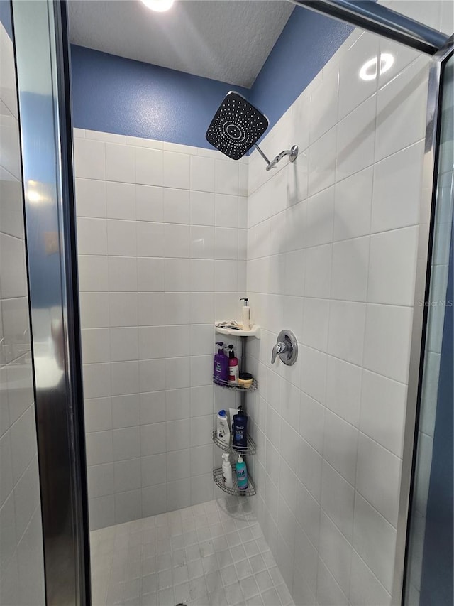 bathroom featuring a tile shower and a textured ceiling