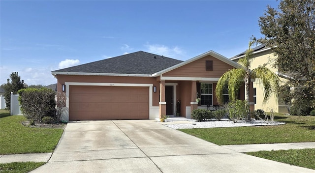view of front facade featuring stucco siding, an attached garage, and a front yard