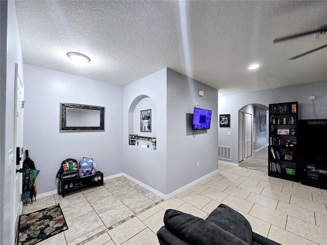 interior space featuring a textured ceiling and light tile patterned floors