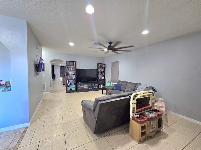 tiled living room with ceiling fan and a textured ceiling