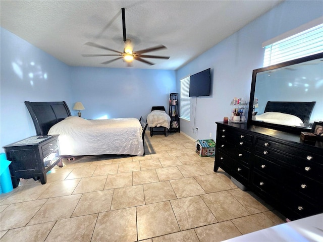 tiled bedroom with a textured ceiling and ceiling fan