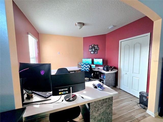 office space featuring light hardwood / wood-style flooring and a textured ceiling