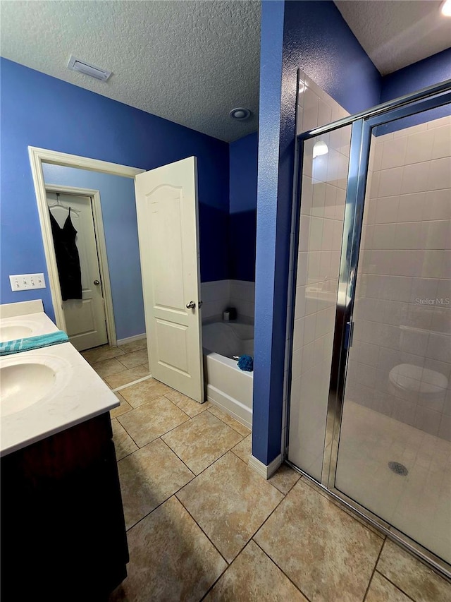 bathroom featuring vanity, shower with separate bathtub, tile patterned flooring, and a textured ceiling