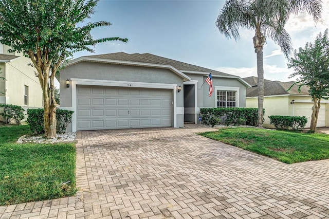 single story home featuring a garage and a front yard