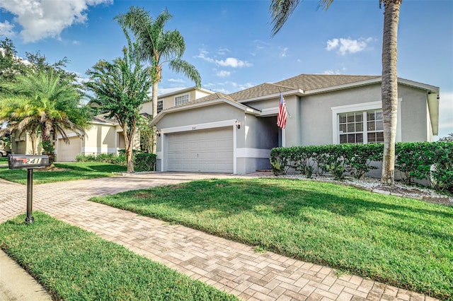 ranch-style house featuring a garage and a front lawn