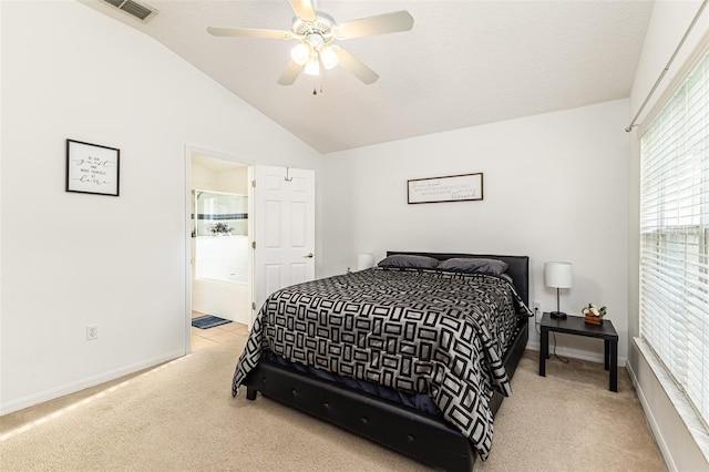 bedroom with vaulted ceiling, ensuite bath, ceiling fan, and light colored carpet