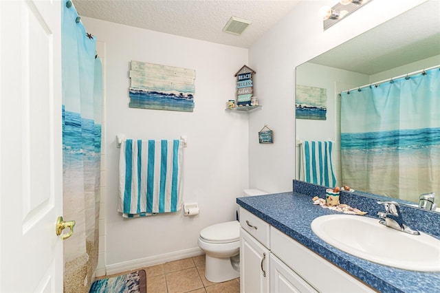 bathroom featuring a textured ceiling, vanity, toilet, and tile patterned floors