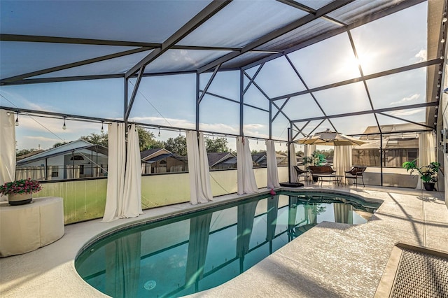 view of pool with glass enclosure and a patio area