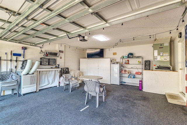 garage with white refrigerator and a garage door opener