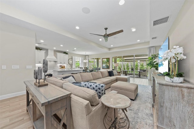 living room featuring light wood-type flooring and ceiling fan