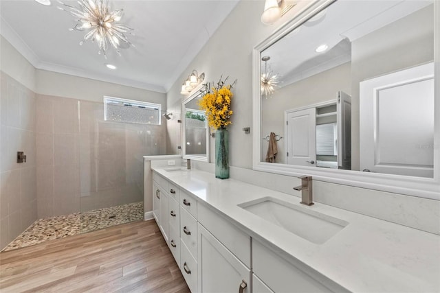 bathroom with crown molding, tiled shower, vanity, and hardwood / wood-style flooring