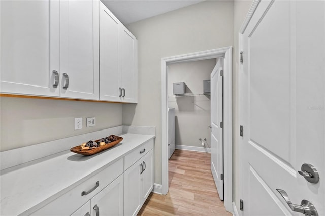 kitchen with light hardwood / wood-style flooring and white cabinetry