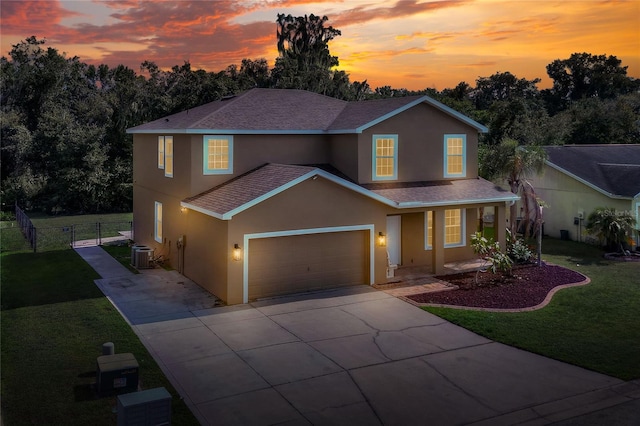 view of front property featuring a lawn, cooling unit, and a garage