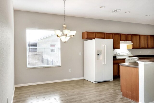 kitchen featuring white appliances, light hardwood / wood-style floors, a chandelier, and hanging light fixtures