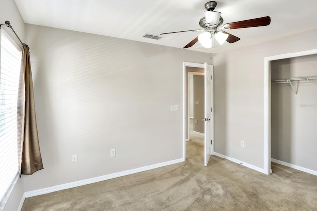 unfurnished bedroom with light carpet, a closet, and ceiling fan