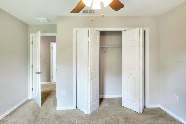 unfurnished bedroom with ceiling fan, light colored carpet, and a closet