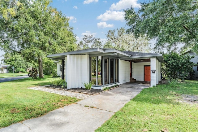 view of front of property featuring a front yard and a carport