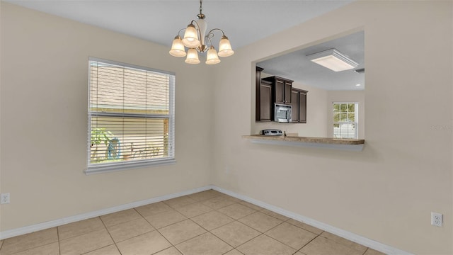 unfurnished dining area featuring a chandelier and light tile patterned flooring