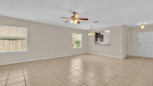 interior space featuring ceiling fan with notable chandelier and light tile patterned flooring