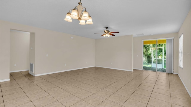 empty room with ceiling fan with notable chandelier and light tile patterned floors