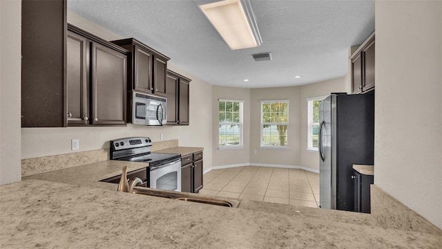 kitchen featuring dark brown cabinets, stainless steel appliances, a textured ceiling, and sink