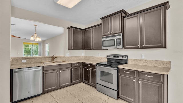 kitchen with light tile patterned flooring, sink, dark brown cabinets, stainless steel appliances, and a notable chandelier