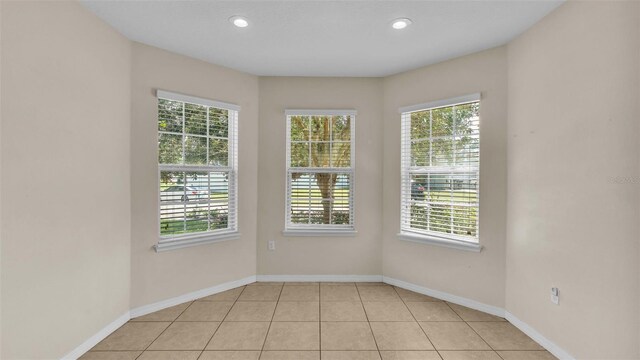 empty room featuring light tile patterned flooring and plenty of natural light