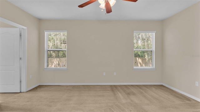 carpeted spare room featuring ceiling fan