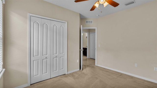 unfurnished bedroom with ceiling fan, a closet, and light carpet