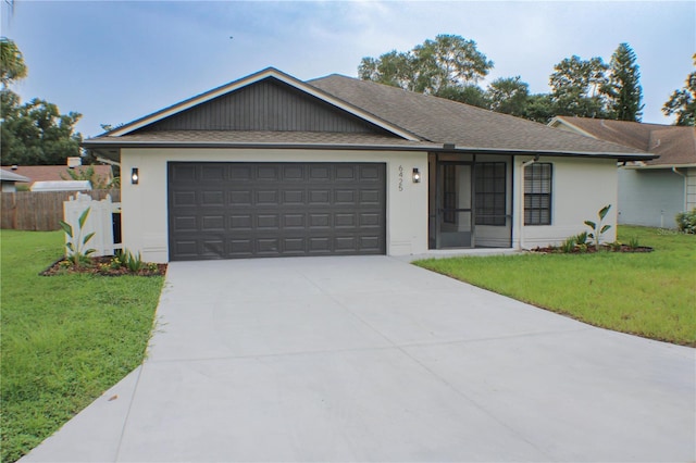 single story home featuring a garage and a front lawn